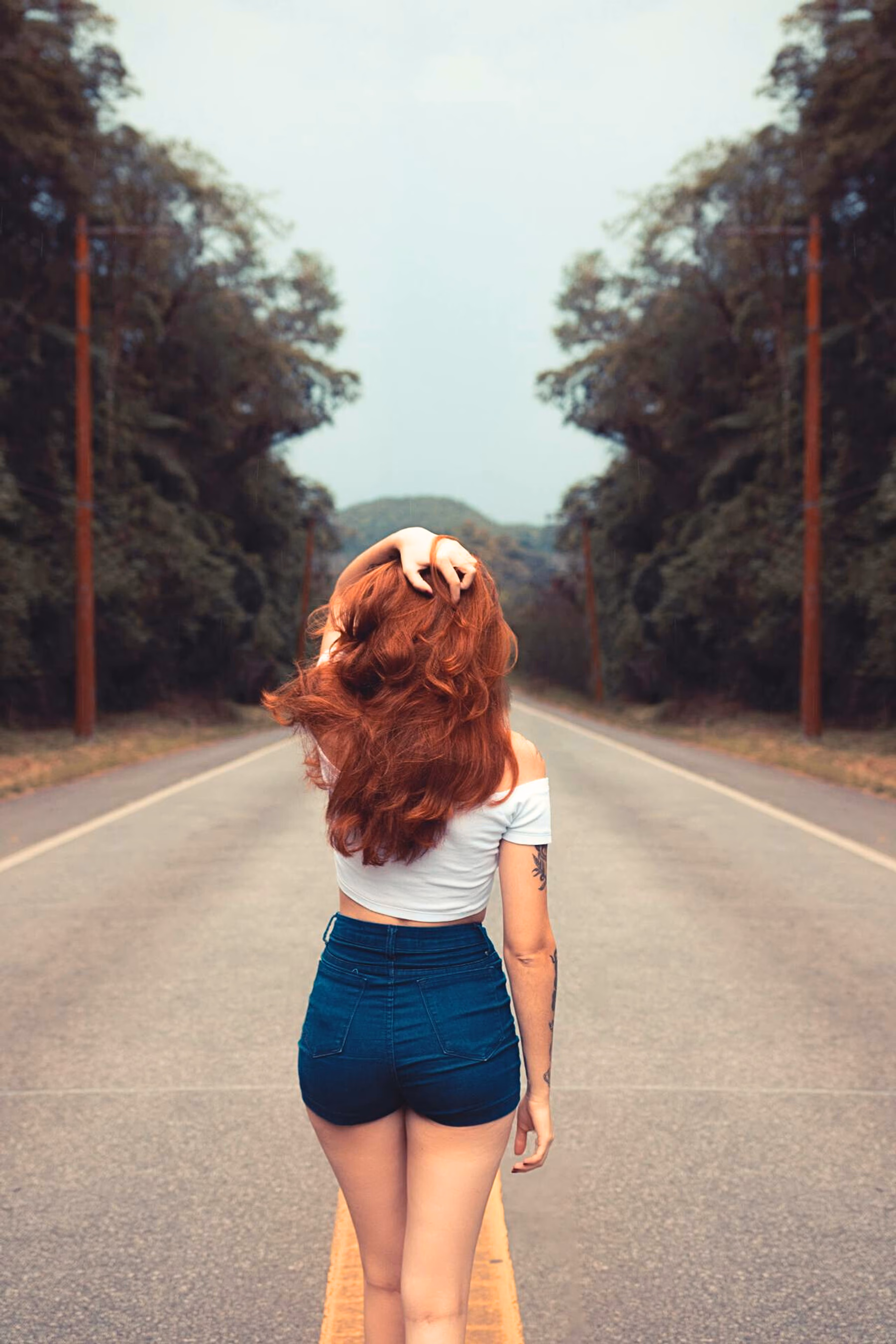 Eine rothaarige Escort Dame läuft in Hannover auf der Straße, von hinten fotografiert