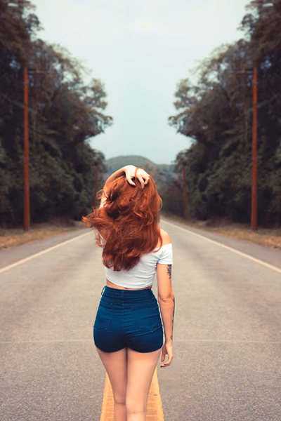 Eine rothaarige Escort Dame läuft in Hannover auf der Straße, von hinten fotografiert