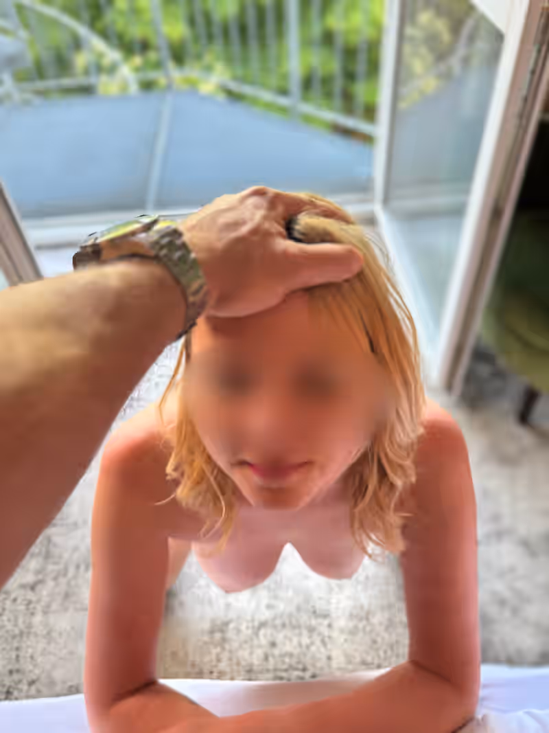 Matilda kniet vor einem Bett, eine männliche Hand drückt ihren Kopf nach unten