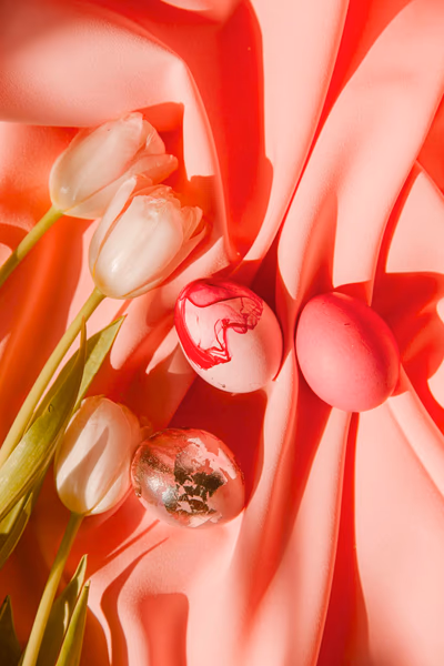 Rosa angemalte Ostereier und rosa-weiße Tulpen