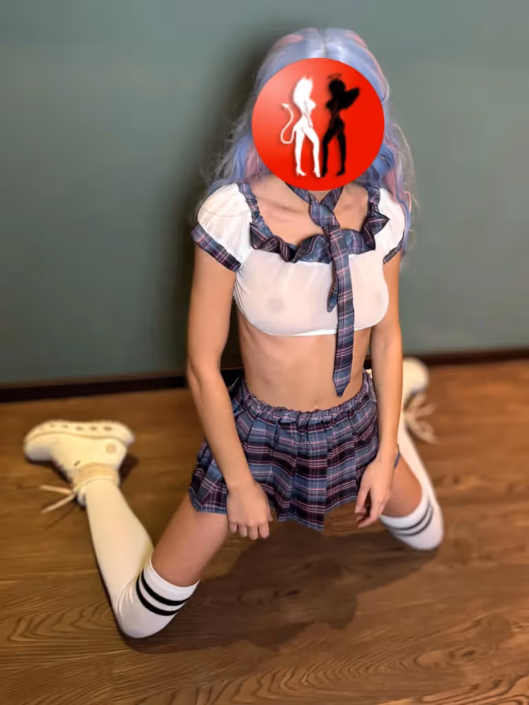 Funtasia kniet als Schulmädchen auf dem Boden